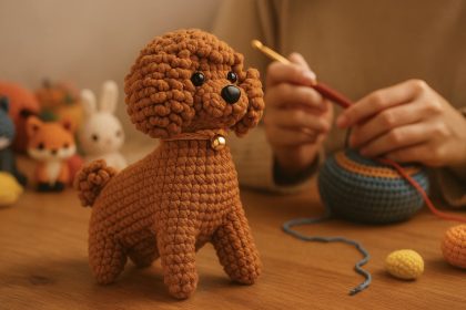 Persona tejiendo un perro de amigurumi con hilo marrón, rodeada de pequeñas figuras de ganchillo de animales en un ambiente cálido y acogedor.